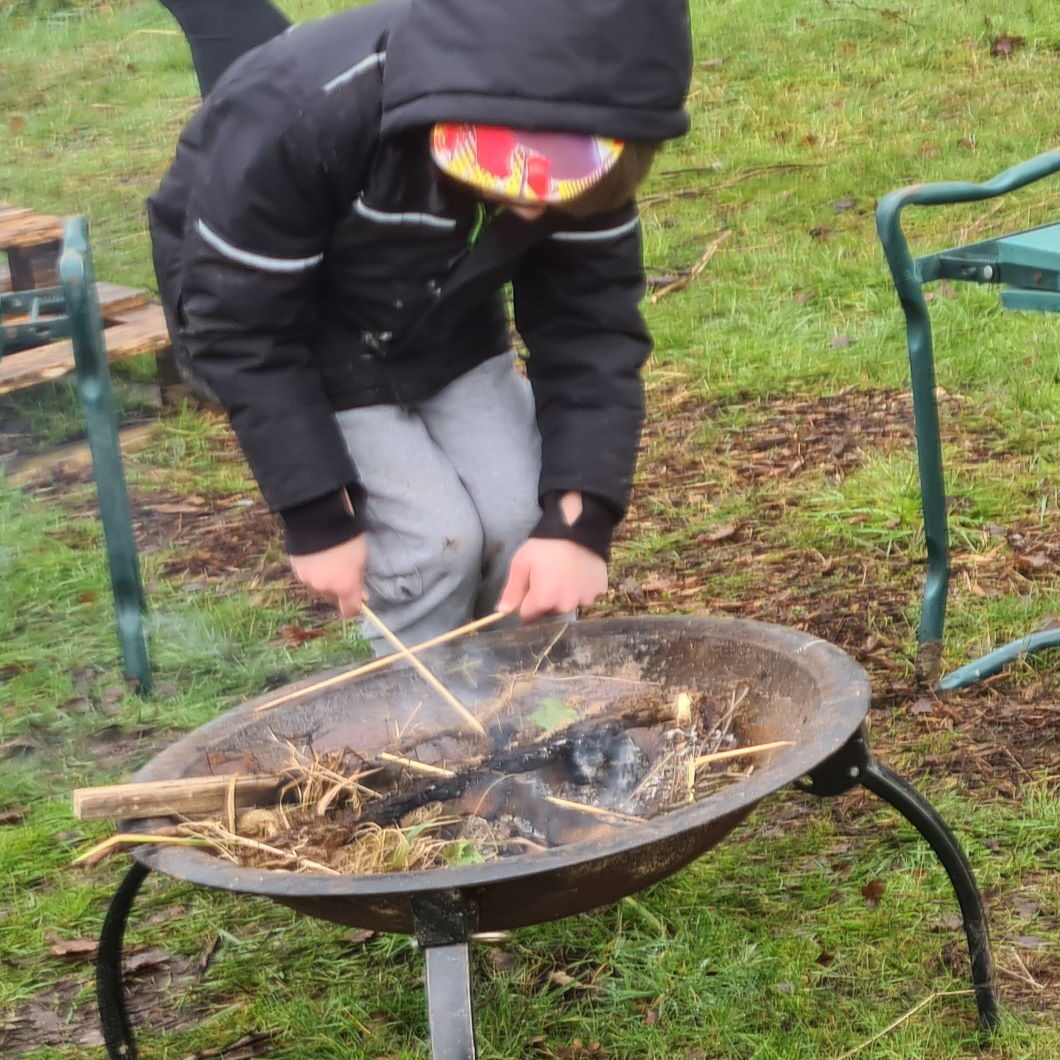 Child toasting marshmallows over a firepit