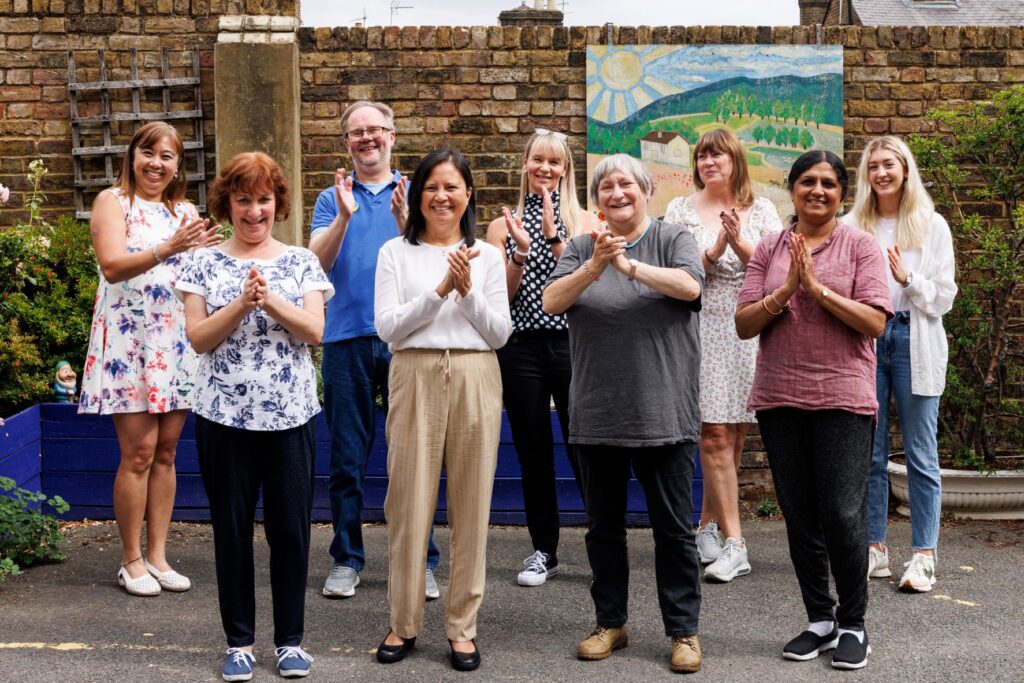 Group of Guideposts Staff standing showing thanks with hands together