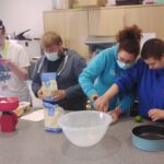 Staff assisting people with cooking in Guideposts day services