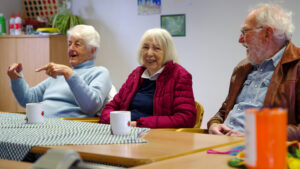 Guideposts members smile and chat at a table.