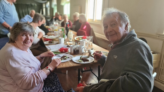 A happy older couple enjoy a meal at Guideposts' Connect with other people