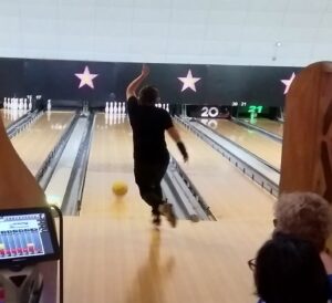 person having just taken their shot at bowling alley