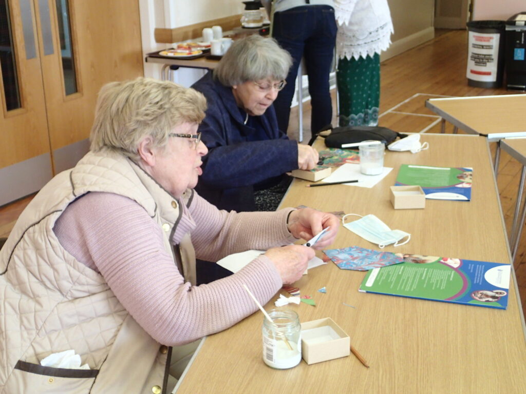 Two older women enjoy crafts at CONNECT.