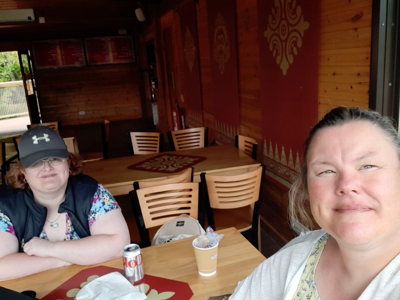 Sam and support worker Jane enjoy a snack in a cafe at the zoo.