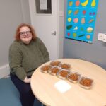 Woman looking really happy with 7 boxed meals ready in front of her