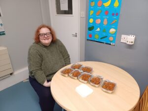 Woman looking really happy with 7 boxed meals ready in front of her