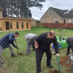 Guideposts gardeners planting trees at Carterton Community Garden