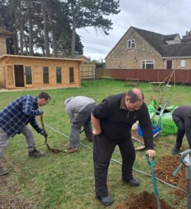 Guideposts gardeners planting trees at Carterton Community Garden