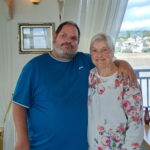 man with his arm around his mother, posing for a photo.