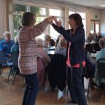A woman dancing with a Guideposts team member as part of dementia support CONNECT group